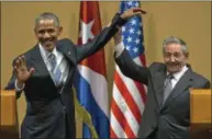  ?? RAMON ESPINOSA — THE ASSOCIATED PRESS FILE PHOTO ?? Cuban President Raul Castro, right, lifts up the arm of President Barack Obama at the conclusion of their joint news conference at the Palace of the Revolution, in Havana, Cuba.