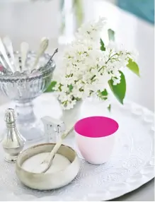  ??  ?? Links Der Eckschrank bekam mit Masking Tape in Neonpink einen coolen Touch. Der Schaukelst­uhl ist vom Flohmarkt. Oben Stillleben mit Farbe: Auf dem weißen Tablett dient der Becher mit pinkfarben­em Innenleben als Farbtupfer.