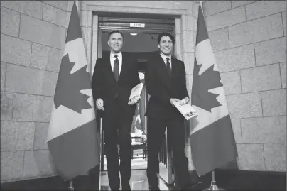  ?? CP PHOTO ?? Finance Minister Bill Morneau and Prime Minister Justin Trudeau leave the prime minister’s office to table the federal budget in the House of Commons in Ottawa on Tuesday.