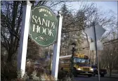  ?? JESSICA HILL — THE ASSOCIATED PRESS FILE ?? A school bus drives past a sign reading Welcome to Sandy Hook in Newtown, Conn., where 26people were killed by a gunman inside Sandy Hook Elementary School.