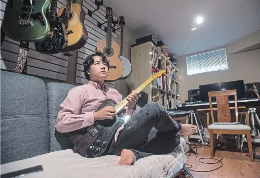  ?? MATHEW MCCARTHY WATERLOO REGION RECORD ?? Nineteen-year-old jazz guitarist David Hjin plays in his bedroom at his Kitchener home. Hear him play by watching the video with this story on therecord.com.