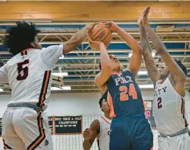  ?? KENNETH K. LAM/BALTIMORE SUN ?? City’s Daniel Parsons blocks a shot by Poly’s Ziyan Gates in front of City’s Camerin Horton during Thursday night’s Class 3A North Region I title game.