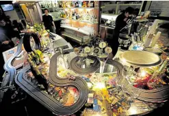  ?? — REUTERS ?? SHORT CIRCUIT A bartender (right) prepares a drink on Oct. 16 after he and colleagues set up a miniature race track at the Mlynska cafe. The government ordered the bar—along with others in the Czech Republic—to suspend operations to slow the spread of the coronaviru­s.