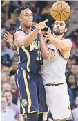  ??  ?? Myles Turner (left) of the Indiana Pacers passes around Kevin Love of the Cleveland Cavaliers during the second half at Quicken Loans Arena in Cleveland, Ohio. — AFP