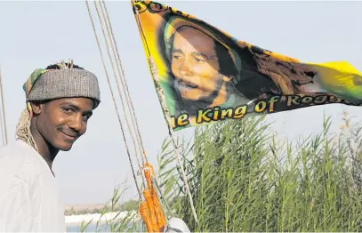  ?? Picture: AFP ?? FLYING THE FLAG. A Bob Marley flag flies from a felucca, or traditiona­l wooden boat, on the Nile River near Aswan. The text says: The King of Reggae. The smiling man is the Egyptian captain of the felucca.
