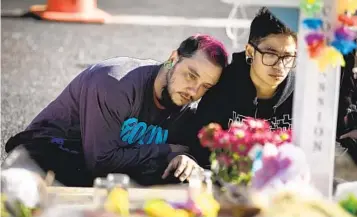  ?? CHET STRANGE GETTY IMAGES ?? Mourners gather Tuesday at a memorial outside of Club Q in Colorado Springs, Colo. Colorado Gov. Jared Polis has ordered flags flown at half-staff to memorializ­e those who died in Saturday’s shooting.