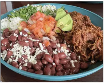  ?? (Arkansas Democrat-Gazette/Eric E. Harrison) ?? El Sur’s Almuerzo del dia ($12.50) is a bowl full of lightly seasoned and cilantro-topped rice, whole beans, Honduran cheese, avocado, pico de gallo, choice of protein — in this case birria (shredded and marinated beef) — and comes with three flat corn tortillas to wrap it into.