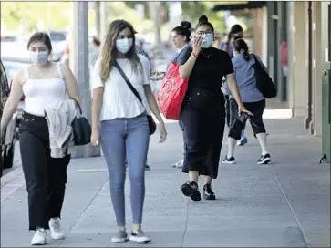  ?? Gary Coronado Los Angeles Times ?? ORANGE COUNTY on Sunday reported 434 new coronaviru­s cases, its highest one-day total for the second day in a row. The death toll reached 269. Above, shoppers stroll near the Orange Circle last week in Orange.