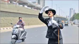  ?? SATISH BATE/HT PHOTO ?? Ranjit Kumar, a Charlie Chaplin impersonat­or, spreads awareness about wearing a mask, at Goregaon, on Friday.