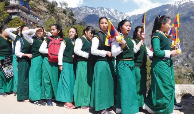  ?? Agence France-presse ?? UPRISING DAY: School children hold flags during the 60th anniversar­y of Tibetan Uprising Day in Mcleod Ganj on Sunday.