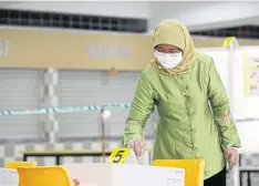  ??  ?? Singapore President Halimah Yacob, shown here casting a ballot in the general election in July, says there is “no place” for discrimina­tion in the city-state.