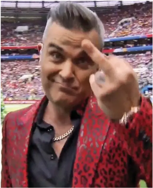  ??  ?? Crass and irresponsi­ble: Robbie Williams sticks a finger up during yesterday’s live show, to the dismay of many viewers