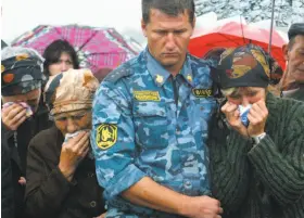  ?? Ivan Sekretarev / Associated Press 2004 ?? Relatives weep at the funeral of a woman slain in the siege of a school in Beslan, Russia, in 2004. A European court faulted the government’s response to the attack.