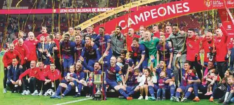  ?? AP ?? ■ Barcelona team pose with the trophy after winning the Copa del Rey final against Sevilla at the Wanda Metropolit­ano stadium in Madrid on Saturday.