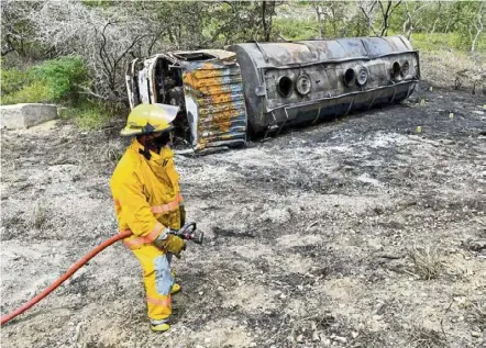 ?? — AFP ?? Death zone: A firefighte­r standing next to the remains of the tanker truck carrying fuel that caught fire in Pueblo Viejo, north of Bogota.