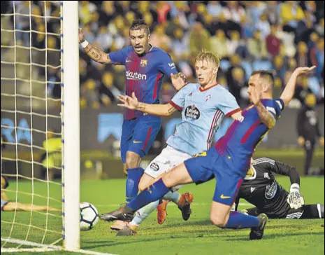  ?? AFP ?? Barcelona forward Paco Alcacer (right) scores past Celta Vigo midfielder Daniel Wass (centre) during their La Liga match on Tuesday.