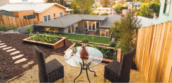  ?? Photos by Quentin Bacon ?? Above: The terraced backyard at 4266 Balfour Ave. in Oakland includes multiple decks, hardscapin­g, planter boxes and drought-tolerant plantings. Below: Craftsman windows welcome natural light into the spacious main level.