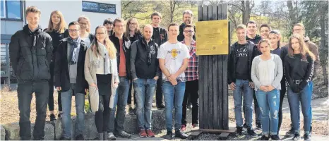  ?? FOTO: PEUTINGER-GYMANSIUM ?? Am Peutinger-Gymnasium wird ein Seminarkur­s „Erinnerung­skultur“angeboten. Die Jugendlich­en haben sich jetzt zu Schülergui­des für Gedenkstät­ten ausbilden lassen. Hier stehen sie vor der Gedenktafe­l der Familie Levy an der Schule.