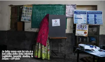  ?? — AFP photo ?? An Indian woman casts her vote at a local polling station during Rajasthan’s Legislativ­e Assembly election, in Jodhpur.