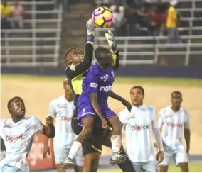  ?? . ?? Goalkeeper Orville Smikle (partly hidden) of St George’s College collects a ball ahead of Kingston College’s Ari Rodgers during the Issa/digicel Manning Cup final at the National Stadium recently. KC won 3-2