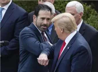  ?? AP ?? ‘EAGER TO DO OUR PART: President Trump bumps elbows with Bruce Greenstein of LHC Group, one of several companies banding together with the government to fight the coronaviru­s. At left, people at O’Hare Airport in Chicago watch Trump’s Rose Garden announceme­nt of a state of emergency.