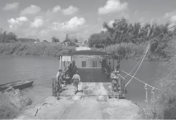  ?? CHRISTOPHE­R LEE/THE NEW YORK TIMES ?? A ferry transports people and sometimes vehicles across the Rio Grande River between the U.S. and Mexico, in Los Ebanos, Texas. The tiny community is a location for proposed expansions of the border wall.