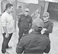  ??  ?? PENJELASAN: Mordi (kiri) diberi taklimat oleh anggota Angkatan Per tahanan Awam Malaysia yang bertugas memantau keadaan mangsa serta situasi banjir kilat di Kampung Jugan, Bau baru-baru ini.
