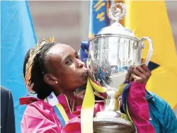  ??  ?? FALL FROM GRACE: In this April 21, 2014 file photo, Rita Jeptoo of Kenya kisses the trophy after winning the women's division of the 118th Boston Marathon in Boston. Former Chicago and Boston Marathon winner Rita Jeptoo has had her doping ban doubled...