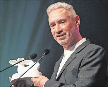  ?? FOTO: BERND BAUR ?? Stolzer Preisträge­r: Roland Emmerich hält das aus weißem Ton gebrannte Laemmle in Händen.