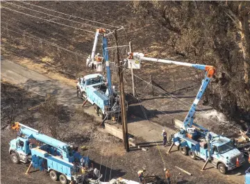  ??  ?? Pacific Gas &amp; Electric Co. (PG&amp;E) employees work to fix downed power lines burned by wildfires in Santa Rosa, California on Oct 12, 2017. — WP-Bloomberg photo by David Paul Morris.