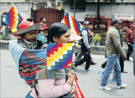  ?? MARCO BELLO / REUTERS ?? Miles de personas portando banderas wiphala de los pueblos andinos marcharon ayer por La Paz en apoyo del expresiden­te Evo Morales