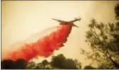  ?? NOAH BERGER — THE ASSOCIATED PRESS ?? An air tanker drops retardant while battling a wildfire fire near Mariposa on Wednesday. According to fire officials, the blaze has scorched more than thousands of acres and destroyed multiple structures.