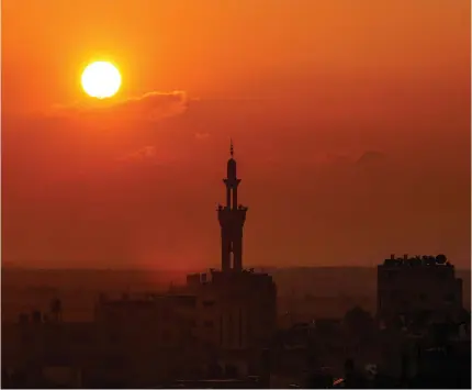  ?? KHATIB / AFP Photo by Said ?? The sun sets behind the minaret of a mosque in Rafah in the southern Gaza Strip on December 31, 2023, amid the ongoing conflict between Israel and the militant group Hamas.