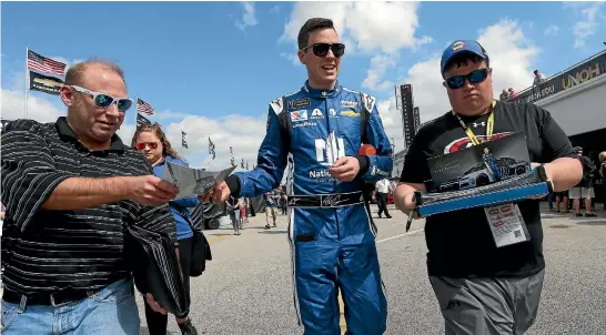  ?? GETTY IMAGES ?? Alex Bowman signs autographs after a practice session for tomorrow’s Daytona 500 at Daytona Beach, Florida.