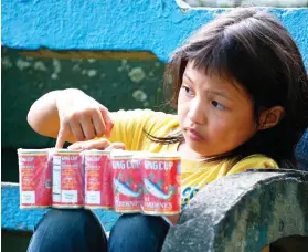  ?? AP FOTO ?? RELIEF GOODS. A child holds a supply of sardines at an evacuation center in Balo-i township, Lanao del Norte. Thousands are in evacuation centers as fighting rages.