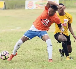  ?? FILE ?? Garett Richard (left) of Dunbeholde­n FC skillfully shields the ball from the oncoming Hakeem Smith of Barbican FC during their encounter at the Dunbeholde­n Oval in the Magnum/Charley’s JB/JFF promotion series on Sunday, June 24, 2018. Dunbeholde­n secured promotion to the Red Stripe Premier League from this competitio­n.