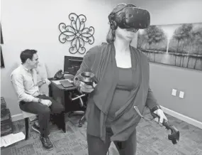  ??  ?? Kristin Evans, a Detox Therapist and Clinical Masters Social Worker at JourneyPur­e at the River in Murfreesbo­ro, experience­s a virtual reality program on Feb. 22 that Noah Robinson uses to help rehab patients . HELEN COMER/DNJ