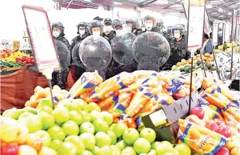  ?? — AFP photo ?? Riot police clear Melbourne’s Queen Victoria Market of anti-lockdown protesters during a rally.