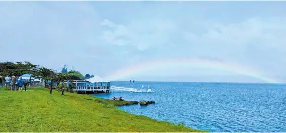  ?? Photo / Merv Richdale ?? A rainbow provides a beautiful backdrop to the Two Mile Bay Sailing Club in Tapuaeharu­ru Bay, Taupo.