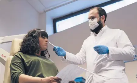  ?? JOHN LEICESTER/AP ?? Dr. Clair Vanderstee­n waves a tube of odors under the nose of a patient, Gabriella Forgione, during tests Feb. 8 in Nice, southern France.