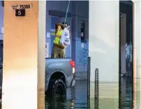  ?? SHIHAB / KHALEEJ TIMES ?? A volunteer uses ropes to deliver food and water to residents in waterlogge­d areas of Al Qasimiya, Sharjah, at midnight.