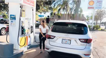  ?? JOE RAEDLE/GETTY ?? Gabriela Chirinos pumps gas into her vehicle amid rising prices Monday at a Shell station in Miami.