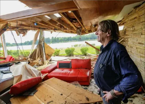  ?? Matthew Hinton/ Associted Press ?? Eric Ehlenberge­r, a physician and neon artist, pauses Wednesday inside his damaged home in New Orleans. He and his wife, Indra Ehlenberge­r, endured a storm spawned by a tropical weather pattern in the Gulf of Mexico. He and his wife were able to crawl out of the house safely.