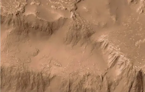  ?? FOTO: NASA ?? Dieses Foto des Mars Reconnaiss­ance Orbiter (MRO) der US-Raumfahrta­gentur Nasa zeigt einen Kraterrand der Tharsis genannten V ulkankette des Mars. Hier floss einst flüssige Lava wie Wasser die Hänge herunter. Heute ist die erstarrte Lava unter Staub...