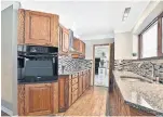  ??  ?? The galley kitchen features custom-built cabinetry, granite counters, built-in appliances.