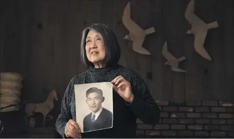  ?? JOANNE KUMAMOTO Allen J. Schaben Los Angeles Times ?? holds a photo of her father, Jiro Oishi, one of the former USC students who will receive an honorary degree.