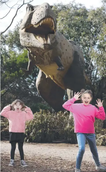  ?? Picture: PETER RISTEVSKI ?? SCARY STUFF: Hannah Allison, 6, and Grace Jarman, 10, freak out on the Dinosaur River Trail, which has returned for another year to the Werribee Zoo.