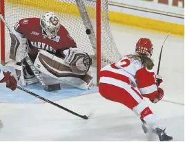  ?? STAFF PHOTO BY JOHN WILCOX ?? NET GAIN: Victoria Bach flips the puck past Harvard goalie Beth Larcom during Boston University’s 3-2 victory last night.