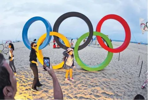  ?? Foto: Witters ?? Sie sind das Fotomotiv an der Copa Cabana in Rio schlechthi­n: die olympische­n Ringe. Doch auch wenn sich die Touristen um ein Foto drängeln, auf den Spielen in Rio liegt schon im Vorfeld ein Schatten, der wohl nicht mehr zu entfernen sein wird.