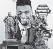  ?? AP PHOTO/JOHN BAZEMORE ?? Alabama quarterbac­k Tua Tagovailoa poses with the trophies after winning The Maxwell Award for being the college football player of the year and the Walter Camp player of the year Thursday in Atlanta.